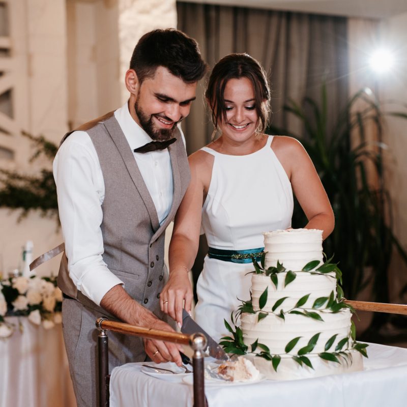 newlyweds-happily-cut-laugh-taste-wedding-cake